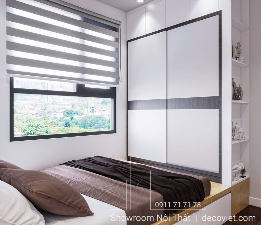 Phòng ngủ căn hộ Opal Boulevard với giường gỗ cạnh cửa sổ lớn.